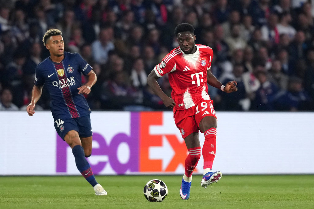 Bayern's Alphonso Davies, right, passes the ball next to PSG's Desire Doue during a Champions League semifinal, first leg, soccer match between Paris Saint-Germain and Bayern Munich in Paris, Tuesday, April 28, 2026. (AP Photo/Aurelien Morissard)