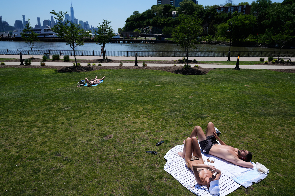 People lay out in the sun in front of the New York City skyline in Hoboken, N.J., Wednesday, May 20, 2026. (AP Photo/Seth Wenig)