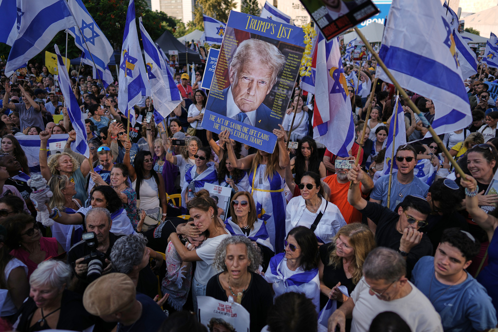 People react as they gather to watch a live broadcast of Israeli hostages released from Gaza at a plaza known as hostages square in Tel Aviv, Israel, Monday, Oct. 13, 2025. The release took place as part of a cease-fire agreement between Israel and Hamas. (AP Photo/Oded Balilty)