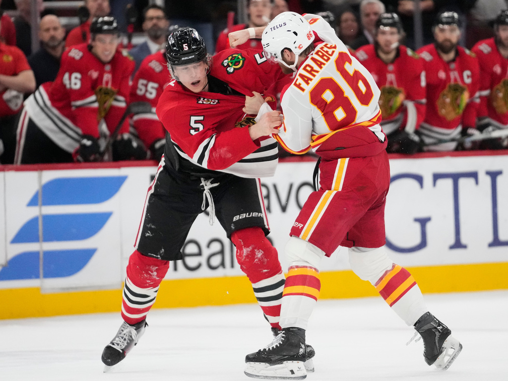Chicago Blackhawks defenseman Connor Murphy (5), left, and Calgary Flames left wing Joel Farabee (86) fight during the second period of an NHL hockey game, Thursday, Jan. 15, 2026, in Chicago. (AP Photo/Erin Hooley)