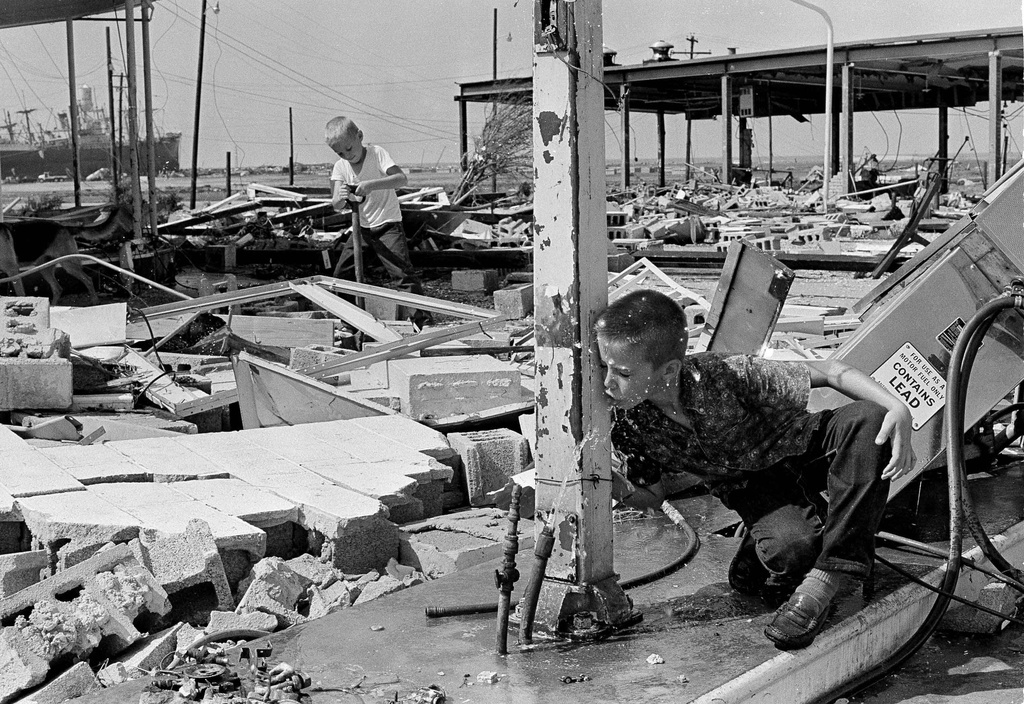 FILE - Carl Wright drinks from a broken pipe amid the ruins of his father's service station in Gulfport, Miss., in the aftermath of Hurricane Camille. (AP Photo/Jack Thornell, File)