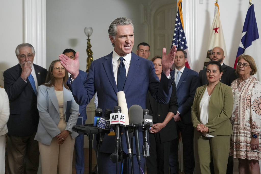 Accompanied by California and Texas lawmakers, California Gov. Gavin Newsom, center, discusses the push to schedule a special election to redraw California's Congressional voting districts, during a news conference in Sacramento, Calif., Friday Aug. 8, 2025. (AP Photo/Rich Pedroncelli)