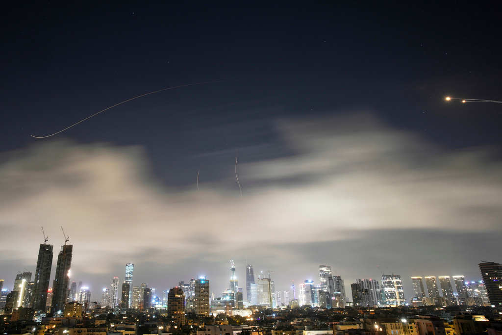 Israeli air defense system fires to intercept missiles during an Iranian attack over Tel Aviv, Israel, early Sunday, March 15, 2026. (AP Photo/Ohad Zwigenberg)