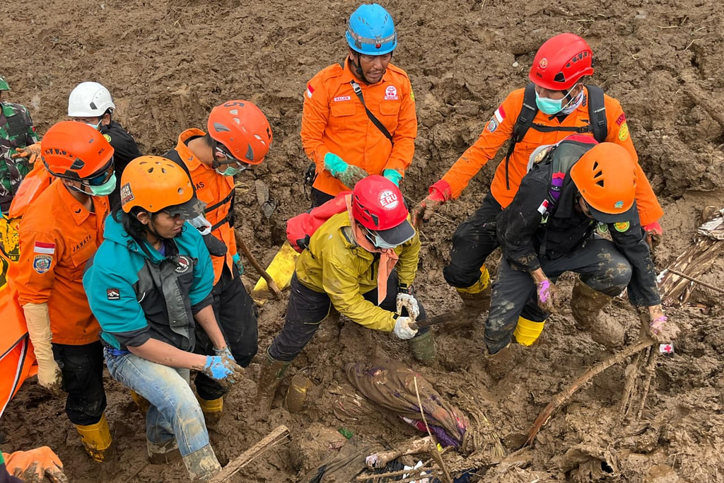 In this photo released by the Indonesian National Search and Rescue Agency (BASARNAS), rescuers search for victims in Pasir Langu village after a landslide, in West Bandung district of West Java province, Indonesia, Sunday, Jan. 25, 2026. (BASARNAS via AP)