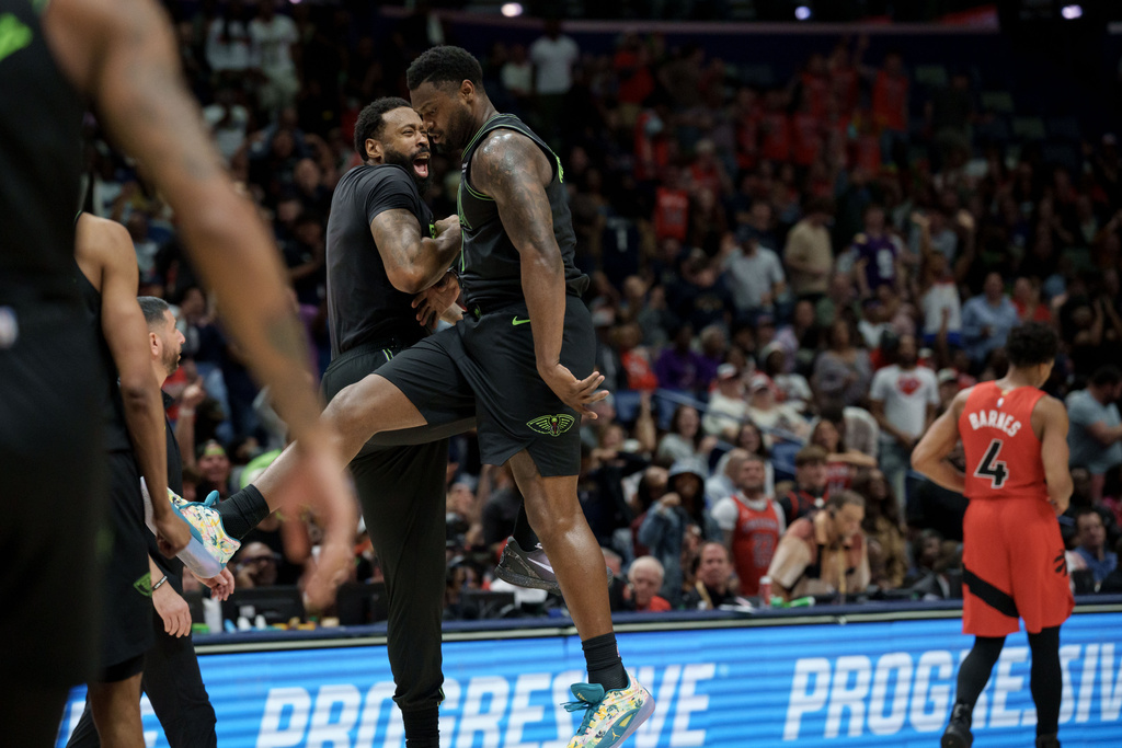 New Orleans Pelicans forward Zion Williamson, center, celebrates a windmill dunk against the Toronto Raptors with center DeAndre Jordan next to Toronto Raptors forward Scottie Barnes (4) during the second half of an NBA basketball game in New Orleans, Wednesday, March 11, 2026. (AP Photo/Matthew Hinton)