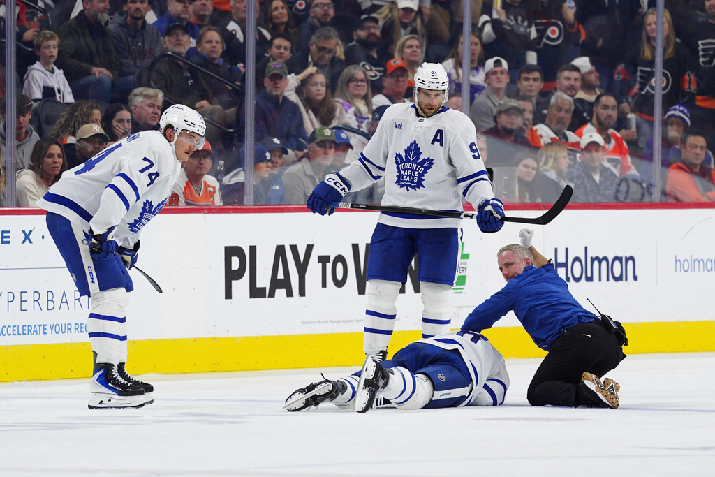 Toronto Maple Leafs' Chris Tanev, bottom, is attended to after a collision during the third period of an NHL hockey game against the Philadelphia Flyers, Saturday, Nov. 1, 2025, in Philadelphia. (AP Photo/Derik Hamilton)