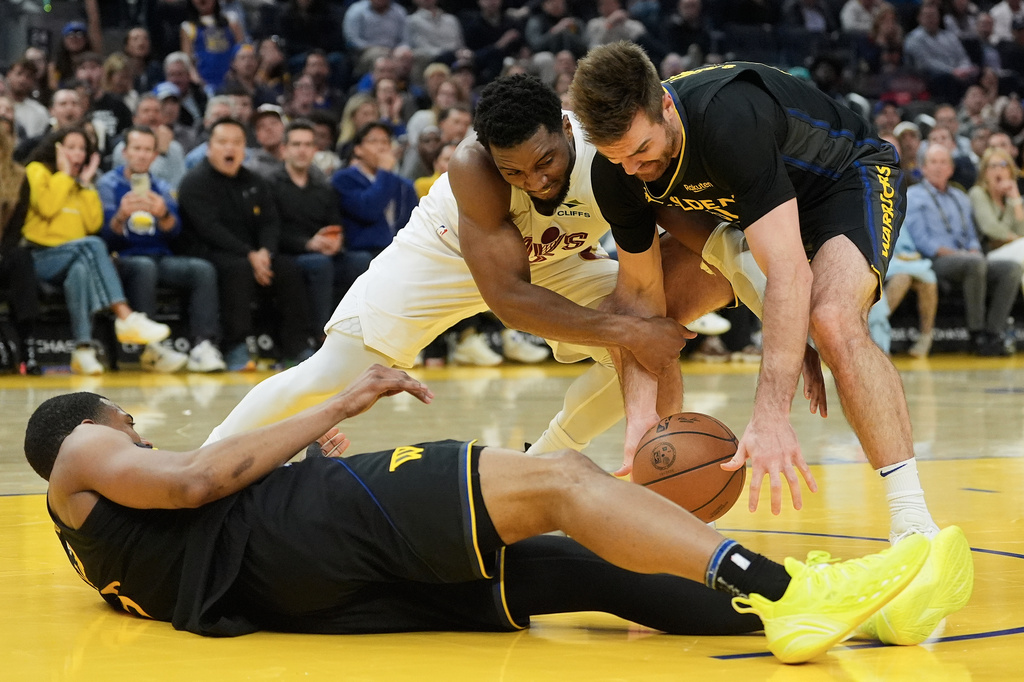 Cleveland Cavaliers guard Donovan Mitchell, middle, reaches for the ball against Golden State Warriors guard Pat Spencer, right, and guard De'Anthony Melton, bottom, during the first half of an NBA basketball game in San Francisco, Thursday, April 2, 2026. (AP Photo/Jeff Chiu)