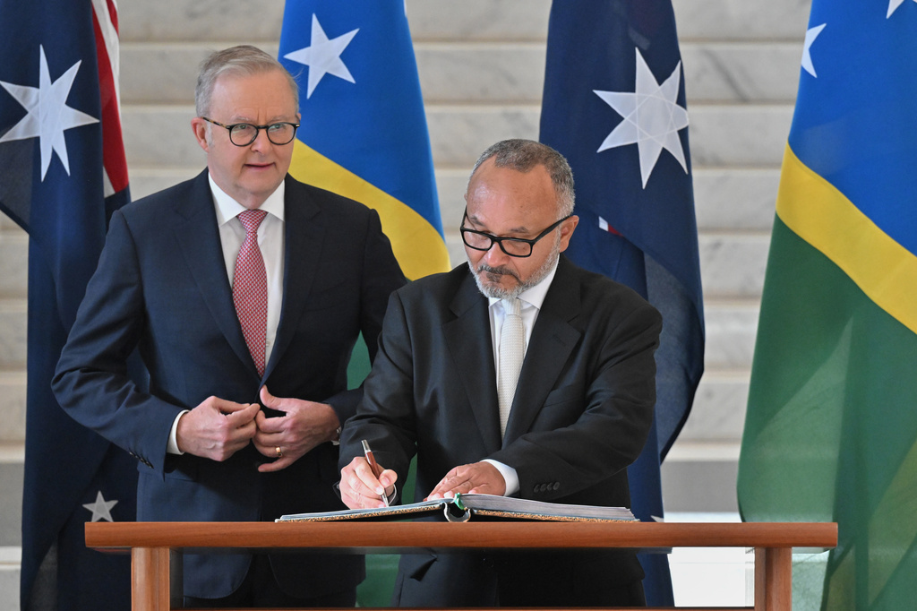 Solomon Islands' Prime Minister Matthew Wale, right, signs a visitors book as Australian Prime Minister Anthony Albanese watches at Parliament House in Canberra, Wednesday, June 3, 2026. (Mick Tsikas/AAP Image via AP)