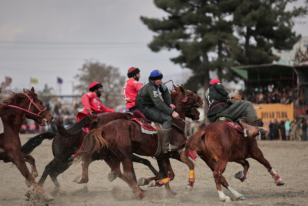 Riders from the Sar-e-Pul and Badakhshan teams compete in the final of Afghanistan's annual buzkashi tournament, a traditional equestrian sport in which riders score points using a fake goat carcass, on the outskirts of Kabul, Afghanistan, Monday, Dec. 22, 2025. (AP Photo)