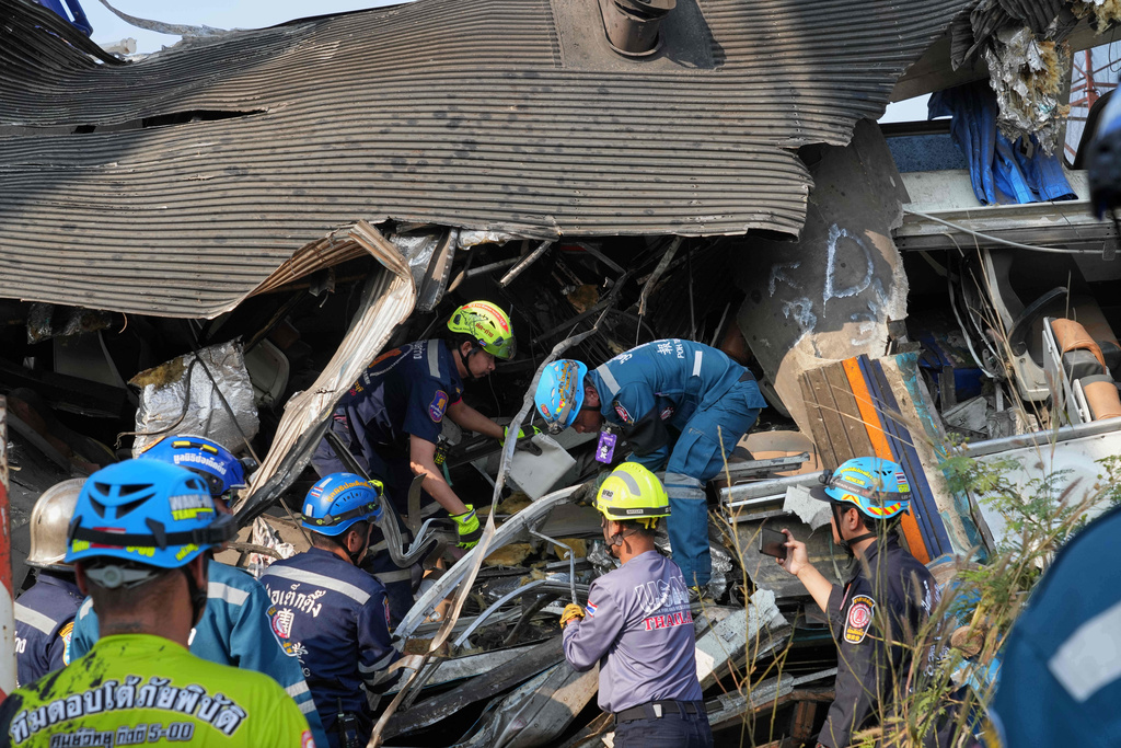 Rescuers work amid the wreckage after a construction crane fell into a passenger train in Nakhon Ratchasima province, Thailand, Wednesday, Jan.14, 2026. (AP Photo/Sakchai Lalit))