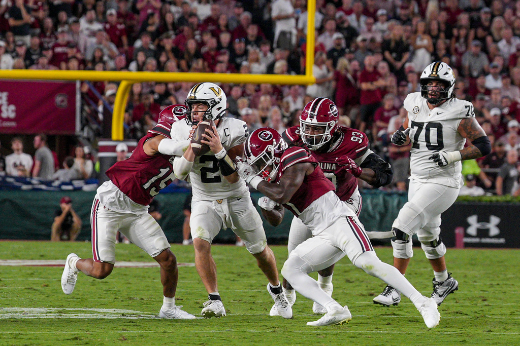 Vanderbilt quarterback Diego Pavia (2) is stopped by South Carolina defensive backs Brandon Cisse (15) and DQ Smith (1) in the first half of an NCAA college football game Saturday, Sept. 13, 2025, in Columbia, S.C. (AP Photo/David Yeazell)