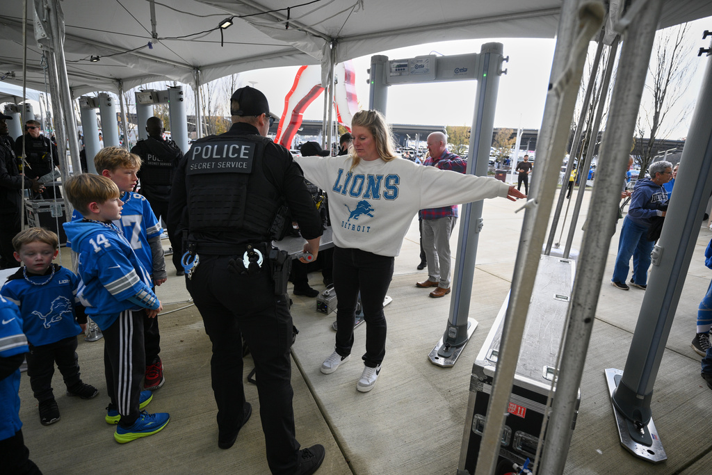 Fans enter through a security checkpoint before an NFL football game between the Washington Commanders and the Detroit Lions Sunday, Nov. 9, 2025, in Landover, Md. (AP Photo/Nick Wass)