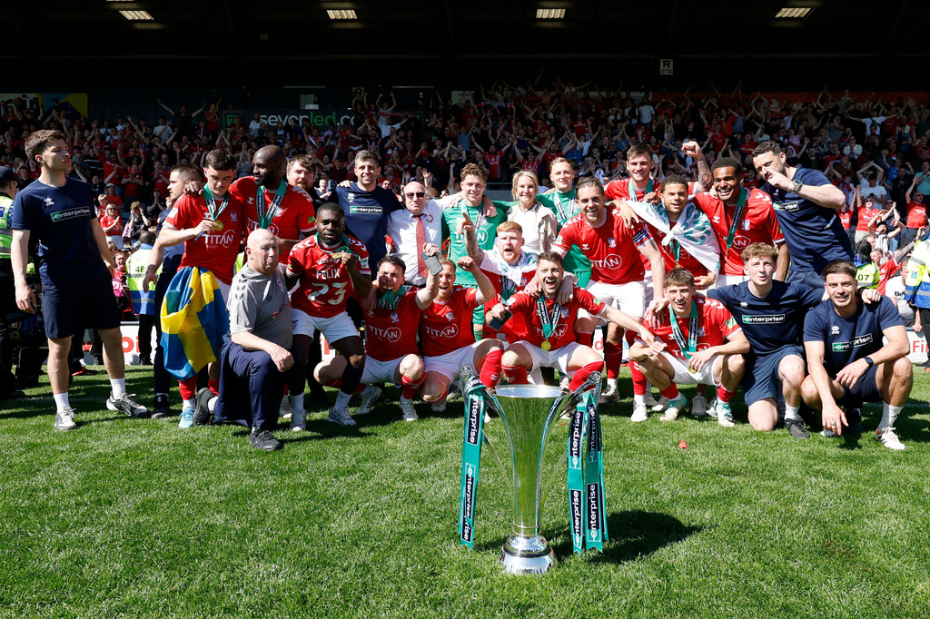 York City players and staff celebrate with the trophy after defeating Rochdale in the National League match in Rochdale, England, Saturday April 25, 2026. (Cody Froggatt/PA via AP)