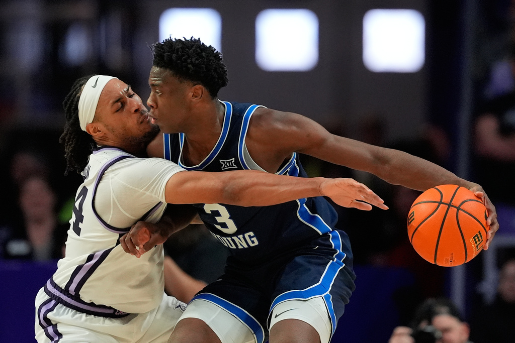 Kansas State guard Nate Johnson, left, tries to steal the ball from BYU forward AJ Dybantsa (3) during the second half of an NCAA college basketball game Saturday, Jan. 3, 2026, in Manhattan, Kan. (AP Photo/Charlie Riedel)
