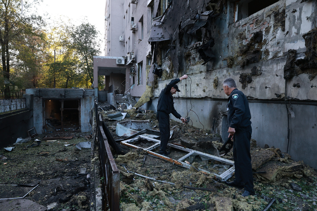 Police officers collect fragments of a drone in front of a hospital damaged in a Russian strike on Zaporizhzhia, Ukraine, Friday, Sept. 25, 2026. (AP Photo/Kateryna Klochko)