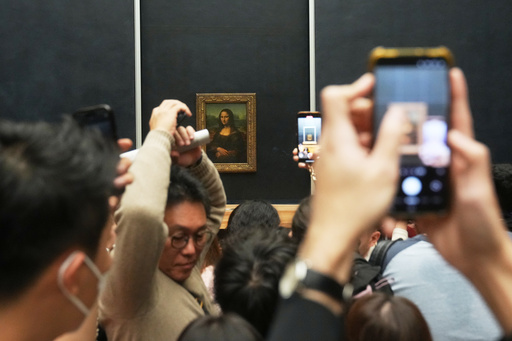 Visitors watch Leonardo da Vinci's painting Mona Lisa in Louvre museum three days after historic jewels were stolen in a daring daylight heist, Wednesday, Oct. 22, 2025 in Paris. (AP Photo/Thibault Camus) Visitors watch Leonardo da Vinci's painting Mona Lisa in Louvre museum three days after historic jewels were stolen in a daring daylight heist, Wednesday, Oct. 22, 2025 in Paris. (AP Photo/Thibault Camus)