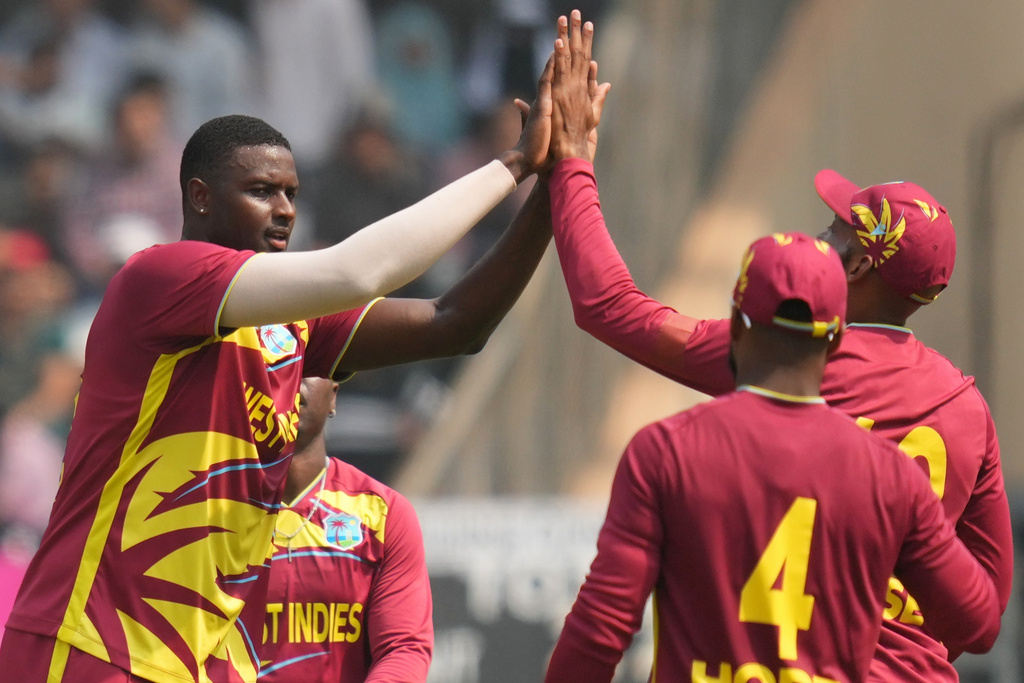 West Indies' Jason Holder, second left, Nepal's Aarif Sheikh during the T20 World Cup cricket match between Nepal and West Indies in Mumbai, India, Sunday, Feb. 15, 2026. (AP Photo/Rafiq Maqbool)