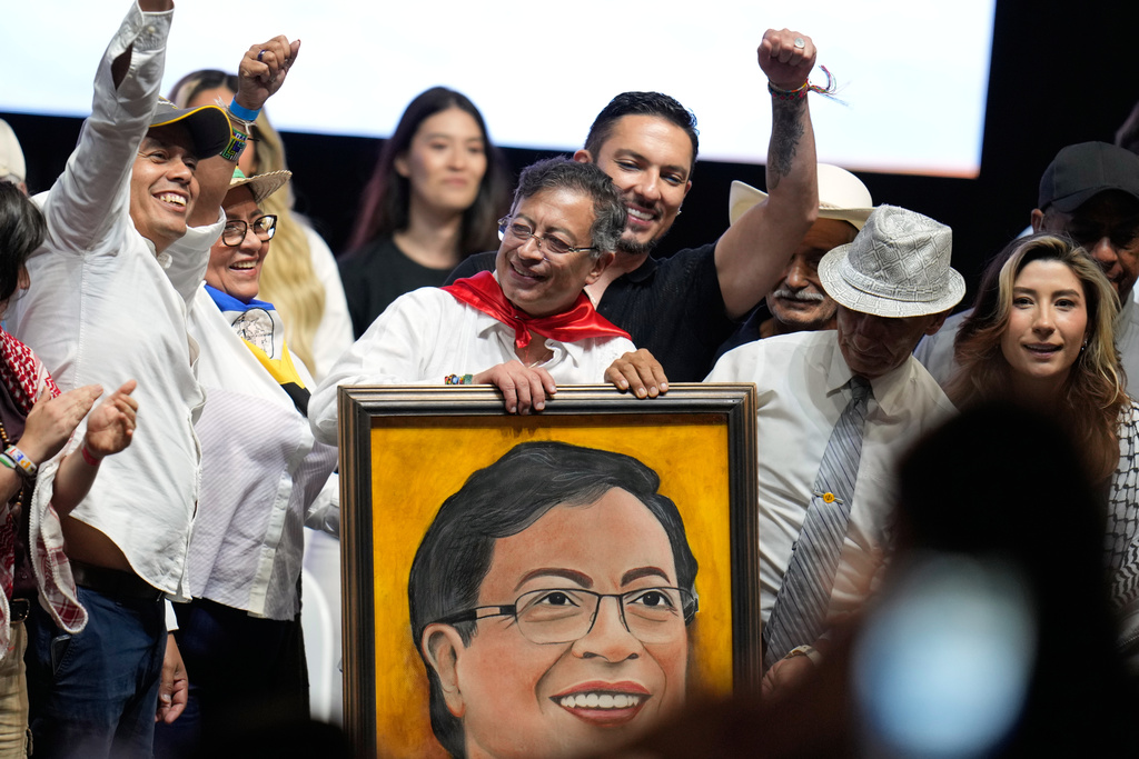 Colombian President Gustavo Petro holds up a portrait given to him by a supporter during a rally in Ibague, Colombia, Friday, Oct. 3, 2025. (AP Photo/ Fernando Vergara)
