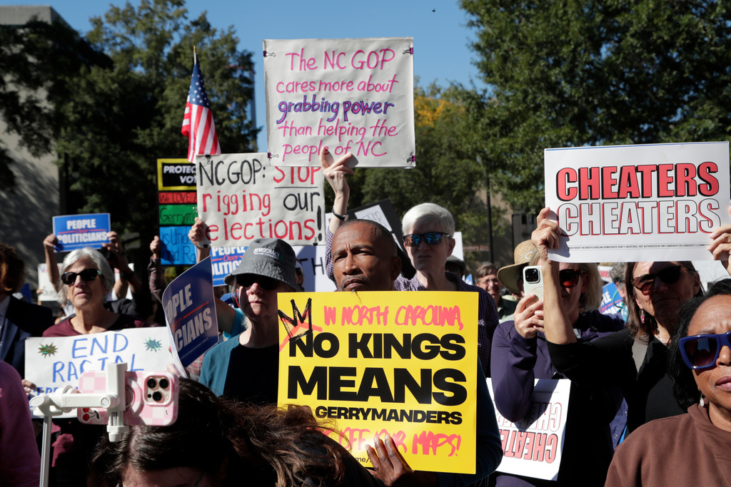 Demonstrators hold signs during a rally protesting a proposed election redistricting map Tuesday, Oct. 21, 2025, in Raleigh, N.C. (AP Photo/Chris Seward)