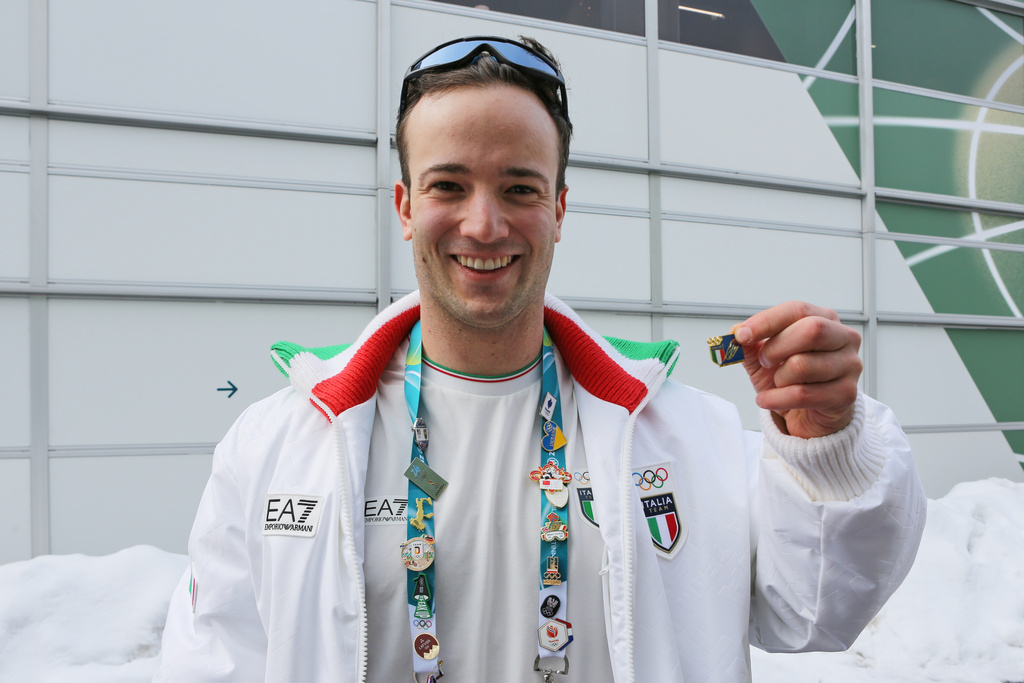 Italian luge athlete Leon Felderer poses for a photo with Italy's national pin, at the Cortina Olympic Village, during the 2026 Winter Olympics, in Cortina d'Ampezzo, Italy, Thursday Feb. 5, 2026. (AP Photo/Jennifer McDermott)