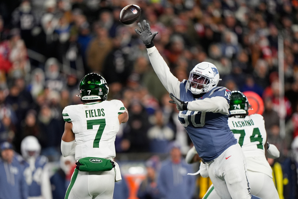 New York Jets quarterback Justin Fields throws a pass under pressure from New England Patriots defensive tackle Christian Barmore during the second half of an NFL football game, Thursday, Nov. 13, 2025, in Foxborough, Mass. (AP Photo/Robert F. Bukaty)