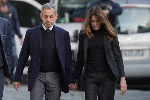 Former French President Nicolas Sarkozy and his wife Carla Bruni-Sarkozy leave their home Tuesday, Oct. 21, 2025 in Paris as Nicolas Sarkozy heads to prison to serve time for a criminal conspiracy to finance his 2007 election campaign with funds from Libya. (AP Photo/Thibault Camus) Former French President Nicolas Sarkozy and his wife Carla Bruni-Sarkozy leave their home Tuesday, Oct. 21, 2025 in Paris as Nicolas Sarkozy heads to prison to serve time for a criminal conspiracy to finance his 2007 election campaign with funds from Libya. (AP Photo/Thibault Camus)