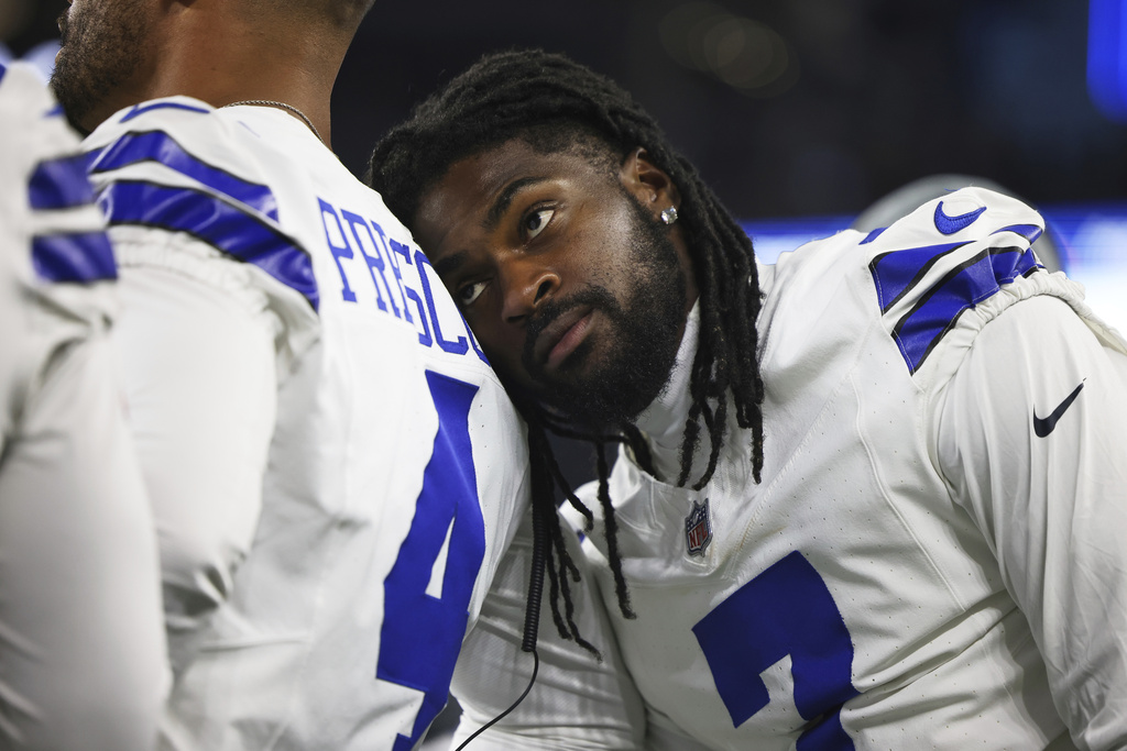 Dallas Cowboys cornerback Trevon Diggs, right, leans on quarterback Dak Prescott (4) as they talk on the sideline in the second half of a preseason NFL football game against the Baltimore Ravens Saturday, Aug. 16, 2025, in Arlington, Texas. (AP Photo/Gareth Patterson)