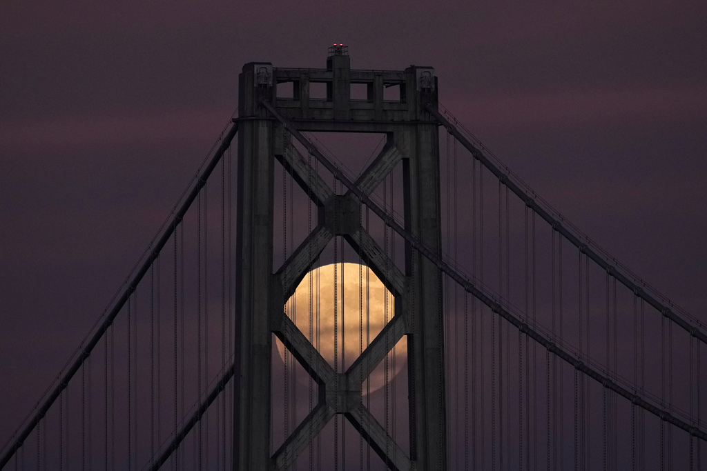 A supermoon, the last full moon of the year, rises behind the San Francisco-Oakland Bay Bridge, Thursday, Dec. 4, 2025, in San Francisco. (AP Photo/Godofredo A. Vásquez)