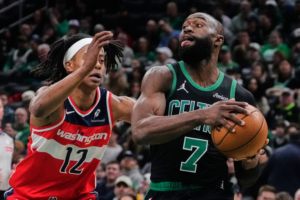 Boston Celtics guard Jaylen Brown (7) drives to the basket past Washington Wizards guard Tre Johnson (12) during the first half of an NBA basketball game, Saturday, March 14, 2026, in Boston. (AP Photo/Charles Krupa)