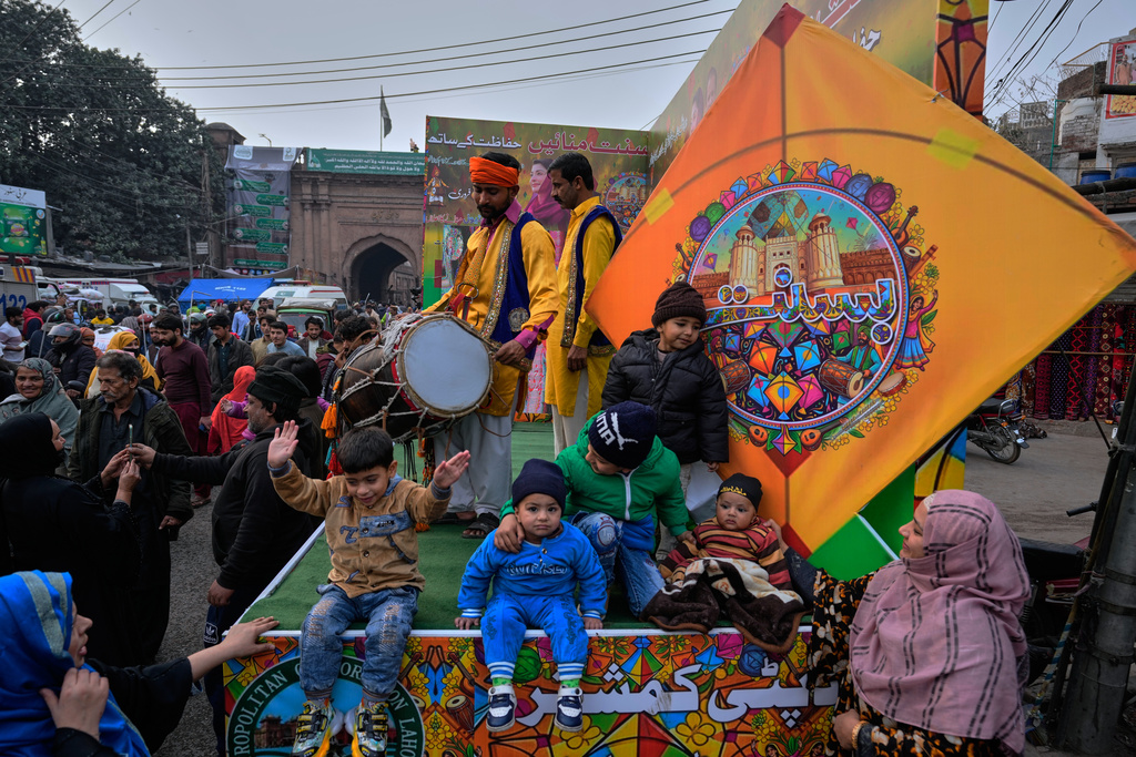 Children pose for a photograph on a truck decorated with colourful kites ahead of the three-day kite flying Basant festival celebration, in Lahore, Pakistan, Tuesday, Feb. 3, 2026. (AP Photo/K.M. Chaudary)