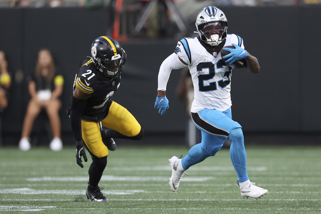 Carolina Panthers running back Trevor Etienne runs past Pittsburgh Steelers safety Chuck Clark during the first half of an NFL preseason football game, Thursday, Aug. 21, 2025, in Charlotte, N.C. (AP Photo/Scott Kinser)