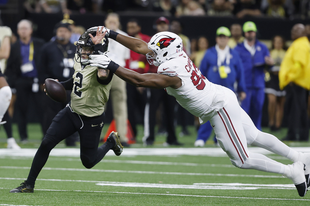 New Orleans Saints quarterback Spencer Rattler (2) tries to run past Arizona Cardinals defensive tackle Calais Campbell during the second half of an NFL football game Sunday, Sept. 7, 2025, in New Orleans. (AP Photo/Butch Dill)