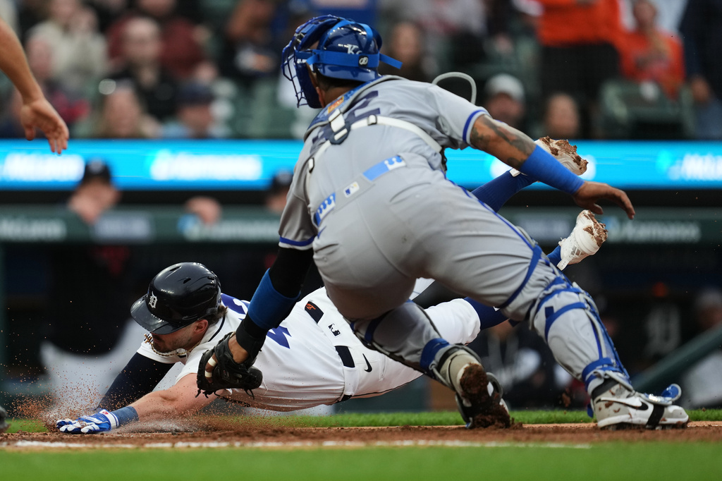 Kansas City Royals catcher Salvador Perez, right, tags Detroit Tigers' Zach McKinstry, left, out at home plate during the third inning of a baseball game Wednesday, April 15, 2026, in Detroit. (AP Photo/Paul Sancya)