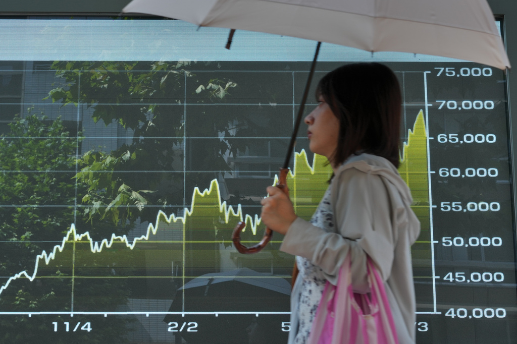 A person walks in front of an electronic stock board showing Japan's Nikkei index at a securities firm Thursday, Aug. 20, 2026, in Tokyo. (AP Photo/Eugene Hoshiko)