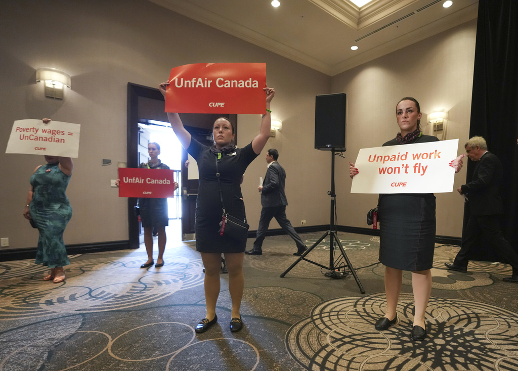 Air Canada executives leave after they are interrupted by Air Canada flight attendants during a press conference as a possible strike looms, in Toronto, on Thursday, Aug. 14, 2025. (Nathan Denette/The Canadian Press via AP)