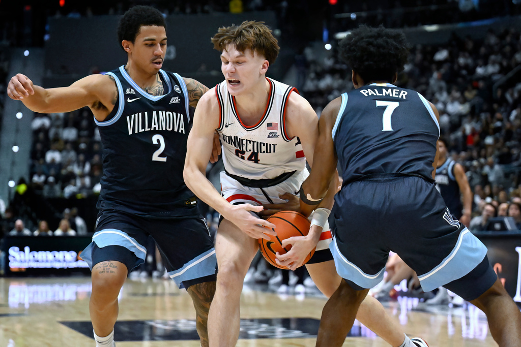 UConn guard Braylon Mullins (24) is guarded by Villanova guards Bryce Lindsay (2) and Malachi Palmer (7) in the first half of an NCAA college basketball game, Saturday, Jan. 24, 2026, in Hartford, Conn. (AP Photo/Jessica Hill)