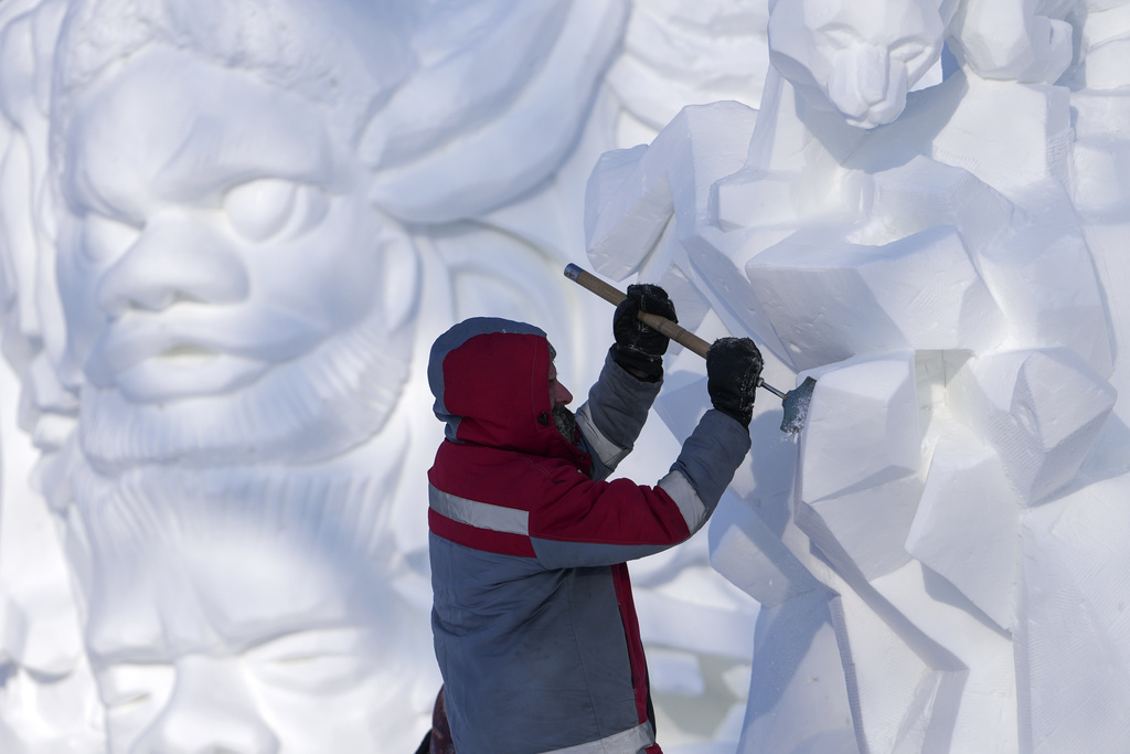 An artist works on a snow sculpture during the Harbin International Snow Sculpture Contest at the Harbin Ice and Snow World in Harbin, China's Heilongjiang province on Wednesday, Jan. 8, 2025. (AP Photo/Andy Wong)