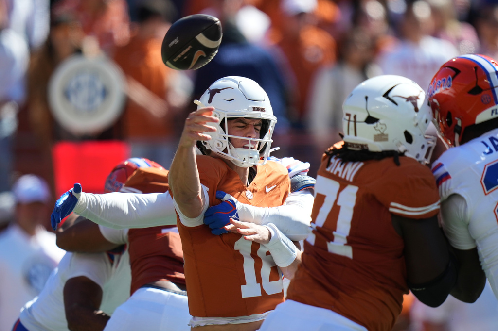 Texas quarterback Arch Manning (16) is hit by Florida linebacker Jaden Robinson (29) as he throw during the first half of an NCAA college football game in Austin, Texas, Saturday, Oct. 17, 2026. (AP Photo/Eric Gay)