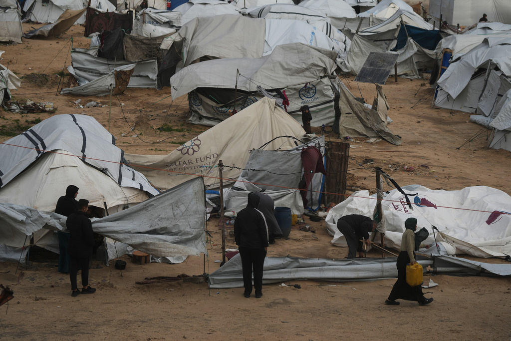 Palestinians repair their tents after they were damaged by a storm at a displacement camp in Gaza City, Tuesday, Jan. 13, 2026. (AP Photo/Jehad Alshrafi)