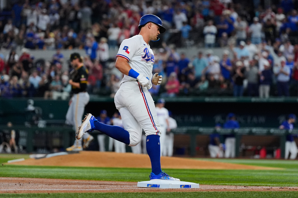Texas Rangers' Josh Jung rounds third after hitting a two-run home run off a pitch from Pittsburgh Pirates pitcher Braxton Ashcraft, left rear, in the second inning of a baseball game Wednesday, April 22, 2026, in Arlington, Texas. (AP Photo/Tony Gutierrez)