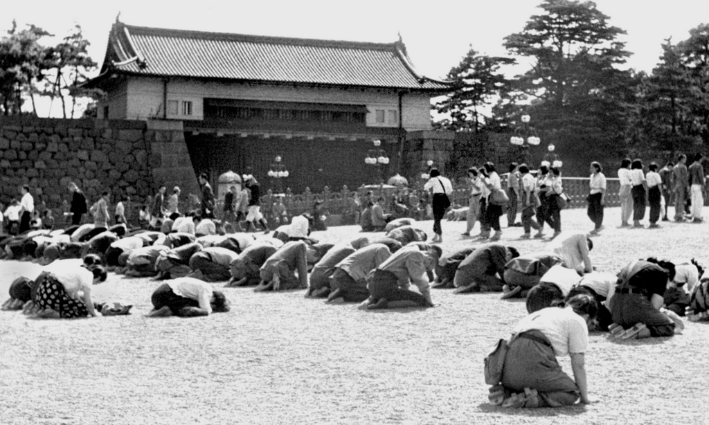FILE - In this Aug. 15, 1945, file photo, Japanese people kneel in front of the Imperial Palace in Tokyo as Emperor Hirohito announced on radio that Japan was defeated in the World War II. (Kyodo News via AP, File)