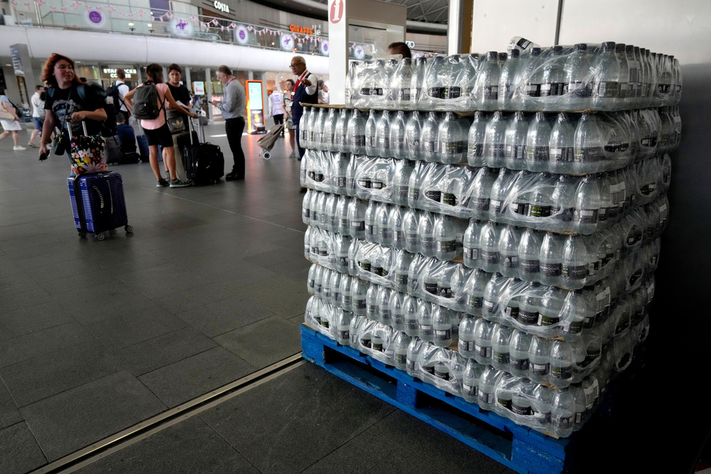 FILE - Bottles of water are piled up to give to passengers at King's Cross railway station where trains are cancelled due to the heat in London, July 19, 2022. (AP Photo/Kirsty Wigglesworth, File)