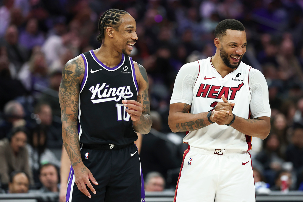 Sacramento Kings guard DeMar DeRozan (10) and Miami Heat guard Norman Powell (24) share a laugh waiting for a technical foul shot during the first half of an NBA basketball game Tuesday, Jan. 20, 2026, in Sacramento, Calif. (AP Photo/Sara Nevis)