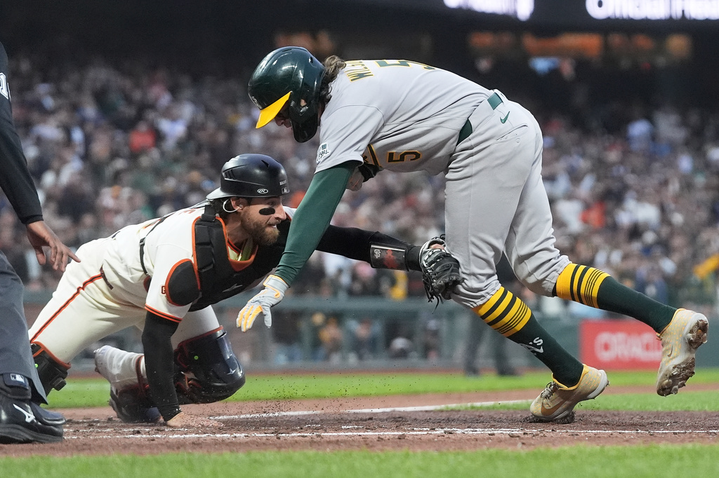 San Francisco Giants catcher Eric Haase, left, reaches to tag out Athletics' Jacob Wilson during the fifth inning of a baseball game Wednesday, June 24, 2026, in San Francisco. (AP Photo/Jeff Chiu)