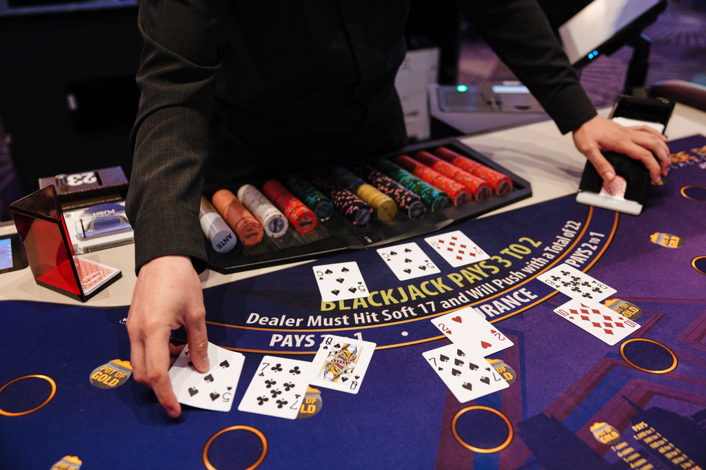 William Eary, a table games dealer at Harrah's Casino, shuffles a deck of cards at the casino in Chandler, Okla., Wednesday, Aug. 5, 2026. (AP Photo/Brittany Bendabout)
