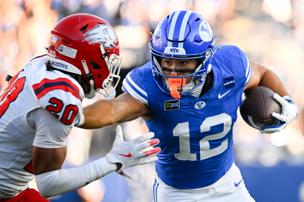 BYU running back Preston Rex (12) runs into Utah Tech defensive back Ryan Tillman (20) in the first half during an NCAA college football game Saturday, Sept. 5, 2026 in Provo, Utah. (AP Photo/Alex Goodlett)