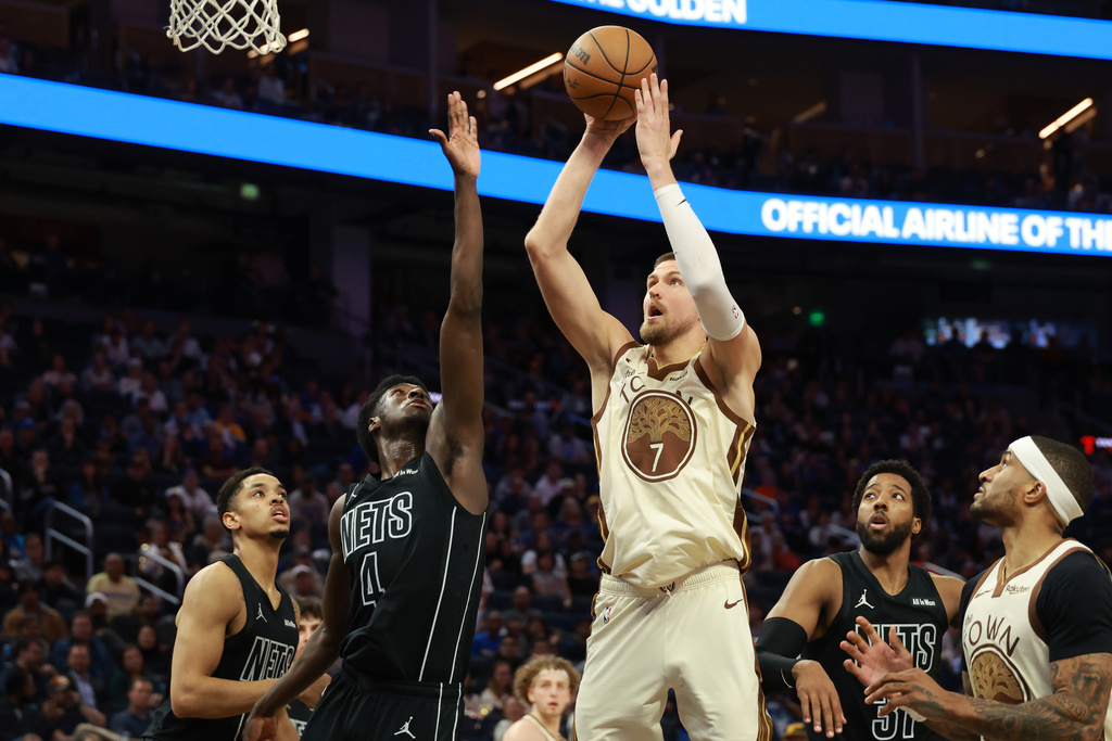 Golden State Warriors center Kristaps Porzingis (7) shoots against Brooklyn Nets guard Drake Powell (4) during the second half of an NBA basketball game in San Francisco, Wednesday, March 25, 2026. (AP Photo/Jed Jacobsohn)