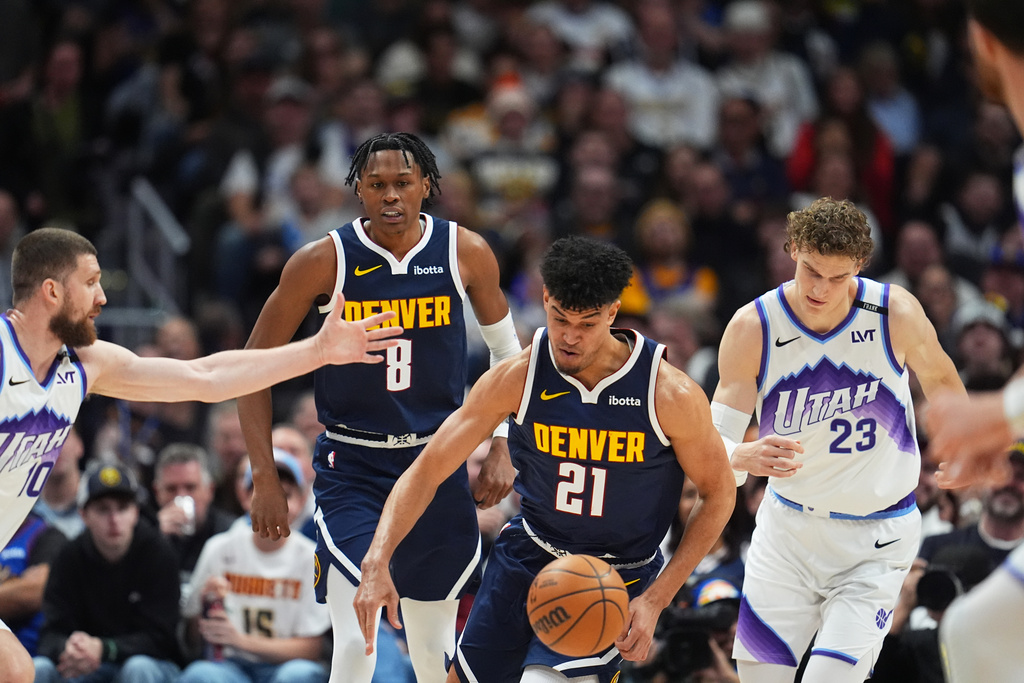 Denver Nuggets forward Spencer Jones, center, collects a loose ball as Utah Jazz forwards Svi Mykhailiuk, left, and Lauri Markkanen defend in the first half of an NBA basketball game Monday, Dec. 22, 2025, in Denver. (AP Photo/David Zalubowski)