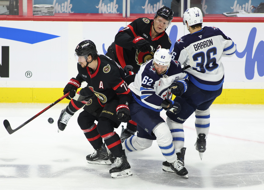 Ottawa Senators' Thomas Chabot (72), Winnipeg Jets' Nino Niederreiter (62), Senators' Brady Tkachuk (7) and Jets' Morgan Barron (36) battle for the puck during the second period of an NHL hockey game in Ottawa, Ontario, on Saturday, Jan. 3, 2026. (Patrick Doyle/The Canadian Press via AP)