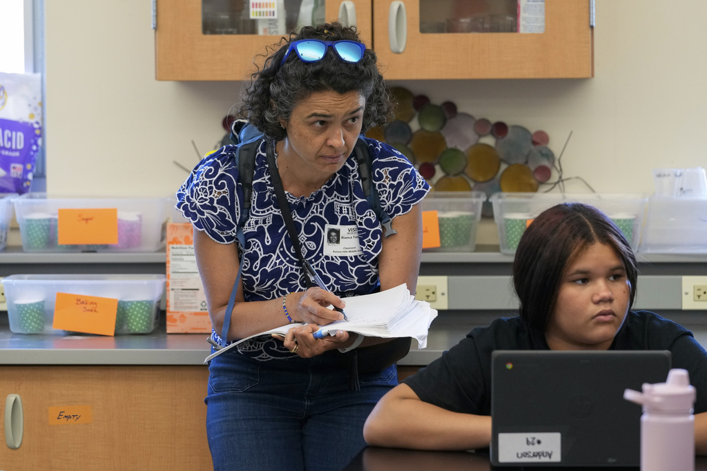 Bianca Vázquez Toness, an AP education writer, takes notes while reporting in a classroom in Aurora, Colo., Aug. 28, 2024. (AP Photo/Godofredo A. Vásquez)